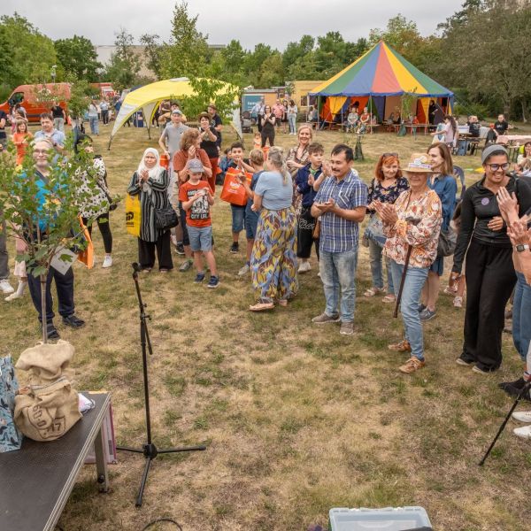 Menschengruppe klatschen vor einer Bühne