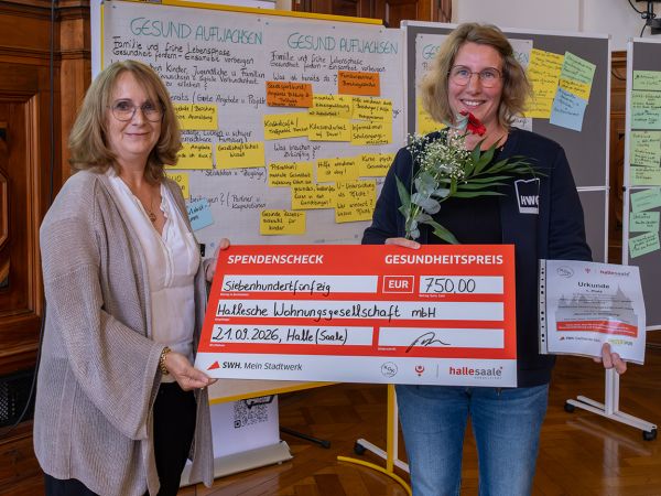 Zwei Frauen halten einen symbolischen Scheck als Gesundheitspreis der Stadt Halle (Saale)