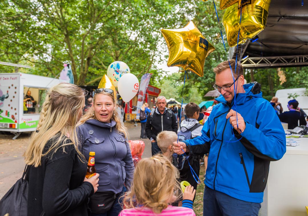 HWG Mitarbeiter verteilt Luftballons an Kinder auf dem Laternenfest