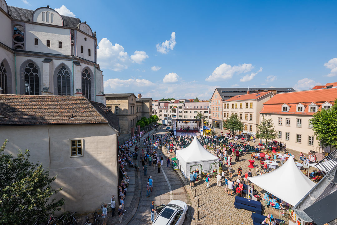 Blick von oben auf das Barockfest am Domplatz mit Bühne und verschiedenen Ständen sowie zahlreichen Besuchern