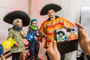 Zwei Kinder sowie ein verkleideter Mexikaner schießen ein Foto