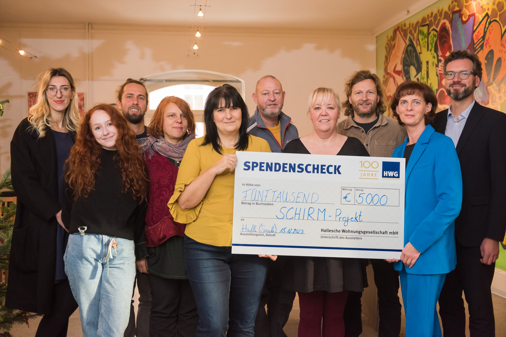 HWG-Geschäftsführerin Simone Danz (2. v.r.) überreicht symbolischen Spendenscheck an Bereichsleiterin Antje Weise (Mitte) sowie weitere Teammitglieder des SCHIRM-Projekts.